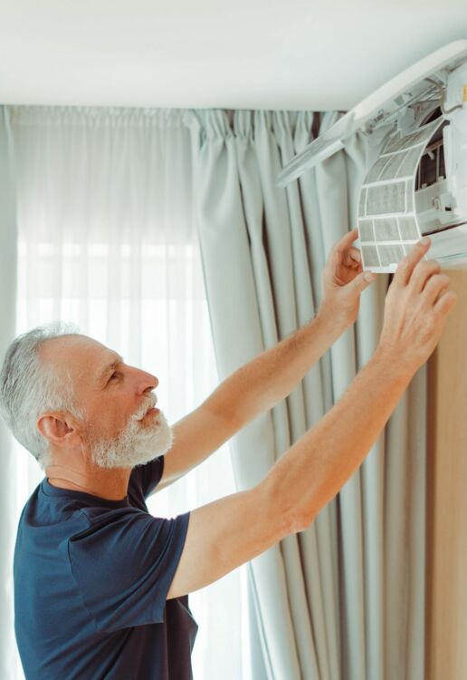 Oudere technieker die airco repareert Gent 